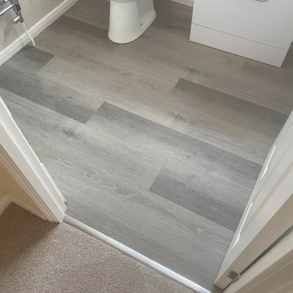 Vinyl flooring with door bars in a bathroom